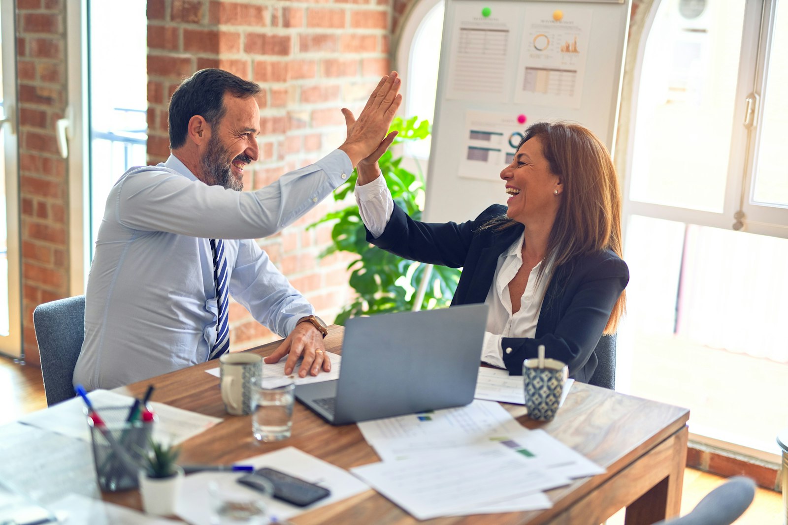 Two business professionals reviewing performance reports in a meeting